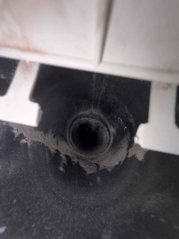 Completed dryer vent cleaning service for non-MVP customer. Thoroughly cleaned the dryer vent system from the appliance connection point through the exterior termination, removing accumulated lint, debris, and dust buildup. Documented pre-existing conditions showing discoloration and residue accumulation around drain pan and vent pipe interior, with visible staining indicating previous moisture exposure or condensate issues in the HVAC system components.