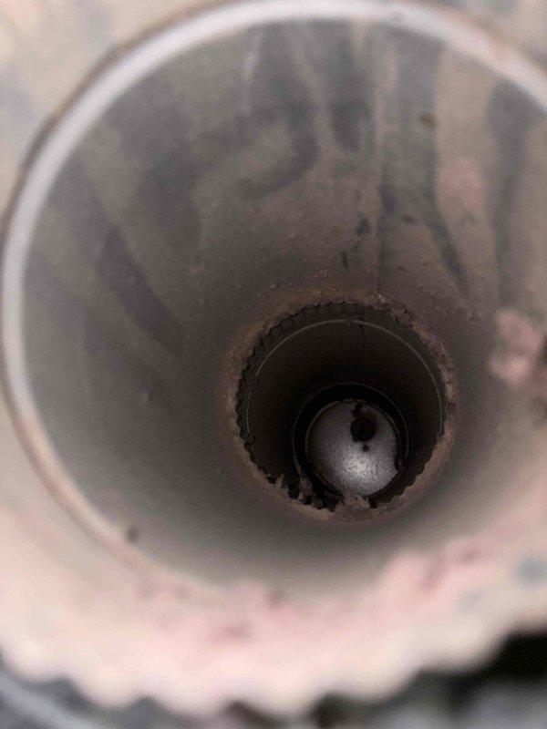 Completed dryer vent cleaning service for non-MVP customer. Thoroughly cleaned the dryer vent system from the appliance connection point through the exterior termination, removing accumulated lint, debris, and dust buildup. Documented pre-existing conditions showing discoloration and residue accumulation around drain pan and vent pipe interior, with visible staining indicating previous moisture exposure or condensate issues in the HVAC system components.