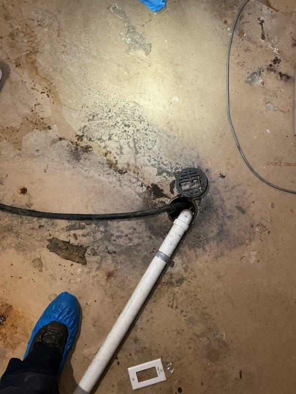 Responded to water backup from basement floor drain. Upon arrival, inspected basement plumbing system including pressure tank, piping connections, and drainage system. Identified water accumulation on concrete floor around plumbing equipment and floor drain area. Assessed main drain line and pressure tank installation for potential blockage or system malfunction causing water to back up through basement drain. Cleared obstruction and verified proper drainage flow restored to prevent further water intrusion into basement.