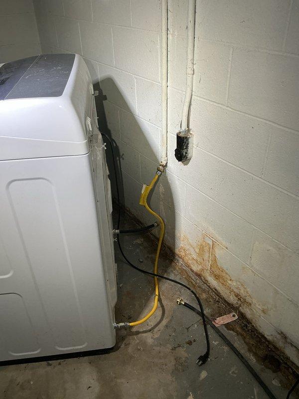 Disconnected flexible gas hose from dryer connection point and shut off gas supply valve to the appliance line. Removed the disconnected gas hose from the area and verified proper valve closure to ensure safe isolation of the gas line, leaving the capped supply line secured in the utility room.