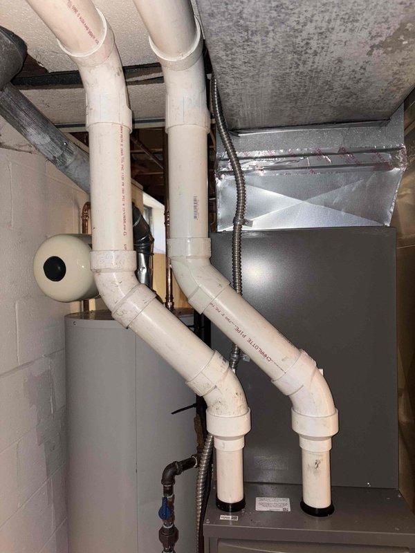 Corrected exhaust venting system by rerunning PVC exhaust pipes in proper configuration per code requirements. Installed new vertical PVC vent runs with appropriate 90-degree elbows and secured all piping with proper mounting straps. Documented completed installation with photographs for municipal reinspection approval.