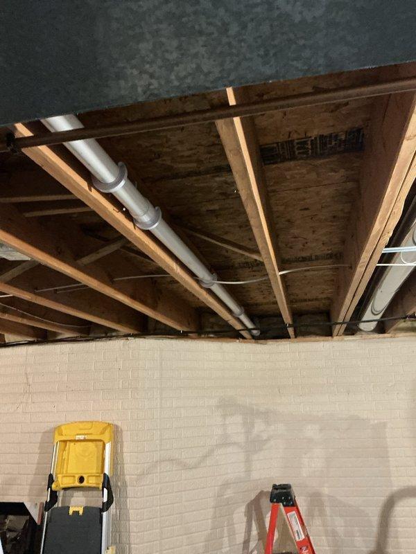 Successfully removed and replaced the existing 1 1/2" kitchen drain line in the basement ceiling, upsizing to 2" piping for improved drainage capacity. Cut out the old line above the 90-degree elbow fitting and installed a new 90-degree elbow oriented forward along the joist direction. Installed a new 3"x2" wye fitting on the main horizontal drain line to properly integrate the upgraded kitchen drain. All work performed with new PVC piping and fittings to ensure code compliance and long-term reliability. Protected work area with drop cloths and restored basement to clean condition upon completion.