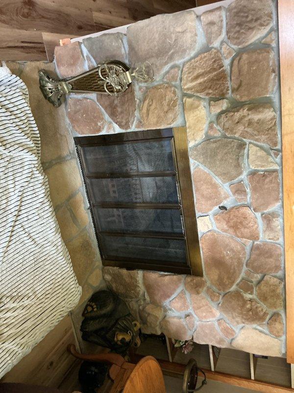 Completed gas line installation to existing stone fireplace to convert from wood-burning to gas operation. Ran new gas supply line from existing source to fireplace location, installed appropriate shutoff valve and connection point for future gas log insert installation. Fireplace features natural stone surround with existing metal screen door that will accommodate gas log conversion upon equipment installation.