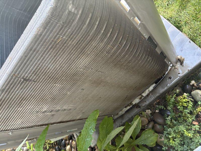 Completed MVP cooling maintenance visit on residential outdoor condensing unit. Inspected condenser coil fins which showed normal weathering and some dirt accumulation, verified proper clearance from surrounding vegetation and confirmed unit was level on concrete pad. Examined and documented electrical components including 30-amp TR30R time-delay fuses rated at 250V AC, which were found in serviceable condition. Inspected condenser fan motor and housing for proper operation and structural integrity.