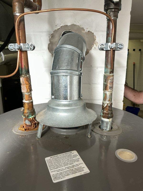 Responded to low water pressure complaint with potential water heater involvement. Upon inspection, discovered severely corroded copper supply piping with heavy verdigris and mineral buildup causing restricted water flow throughout the system. Pressure gauge reading showed 80 psi at the water heater, indicating adequate incoming pressure but compromised delivery due to deteriorated copper lines. Documented extensive corrosion on hot water supply pipes connected to water heater assembly, with flaking copper and white mineral deposits significantly reducing internal pipe diameter. Photographed corroded plumbing components and pressure relief valve assembly for service records. Advised that copper pipe replacement would be necessary to restore proper water pressure and prevent future system failure.
