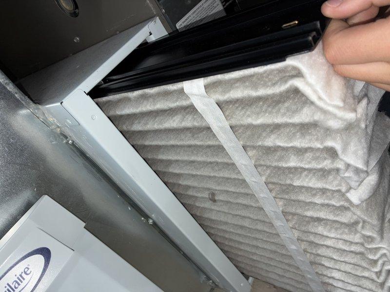 Performed preventative maintenance tune-up on a 2-year-old Lennox system to maintain warranty compliance. Inspected evaporator coil assembly and verified proper fin alignment and heat exchange surface condition, noting light dust accumulation on metallic fins. Accessed air handler compartment, inspected and evaluated pleated air filter showing normal dust accumulation for a residential system in service. Verified all system components operational with proper airflow through ductwork and filter housing. System confirmed working properly with no deficiencies noted during inspection.