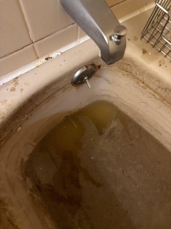 Responded to multiple drain blockages throughout residential property. Addressed upstairs hallway bathroom sink with complete clog and standing water by clearing obstruction from drain line and P-trap assembly. Cleared separate blockages in upstairs hallway traditional bathtub and north-side bedroom walk-in shower, both presenting with standing water due to complete drainage failure. Serviced downstairs powder room bathroom sink experiencing slow drainage from disuse and sediment accumulation. Inspected kitchen sink faucet connections for reported intermittent drip and tightened supply line fittings as needed. Verified proper drainage flow on all affected fixtures after clearing obstructions. All drains restored to normal operation with no additional issues identified on third upstairs walk-in shower which remained functional throughout.
