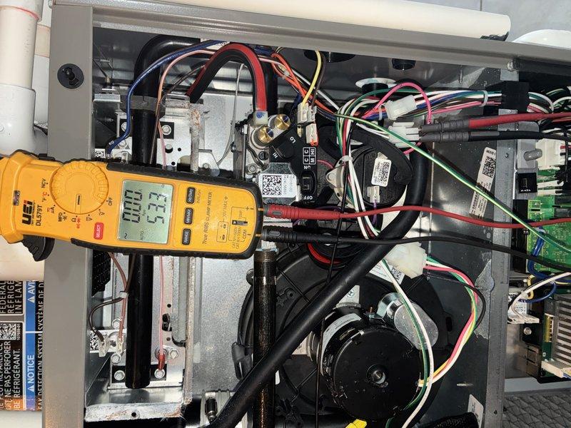 Completed MVP heating maintenance visit on residential HVAC system. Performed diagnostic testing of electrical components using digital multimeter, recording voltage readings of 33.5V within the control compartment. Inspected and tested temperature sensor assembly, examining the probe element and mounting bracket for proper operation and secure installation.