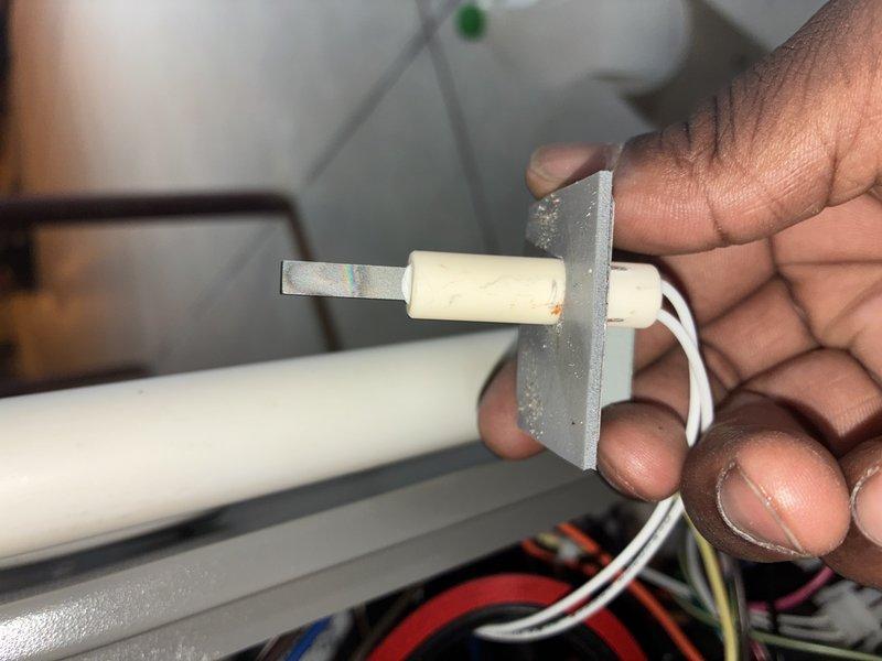 Completed MVP heating maintenance visit on residential HVAC system. Performed diagnostic testing of electrical components using digital multimeter, recording voltage readings of 33.5V within the control compartment. Inspected and tested temperature sensor assembly, examining the probe element and mounting bracket for proper operation and secure installation.