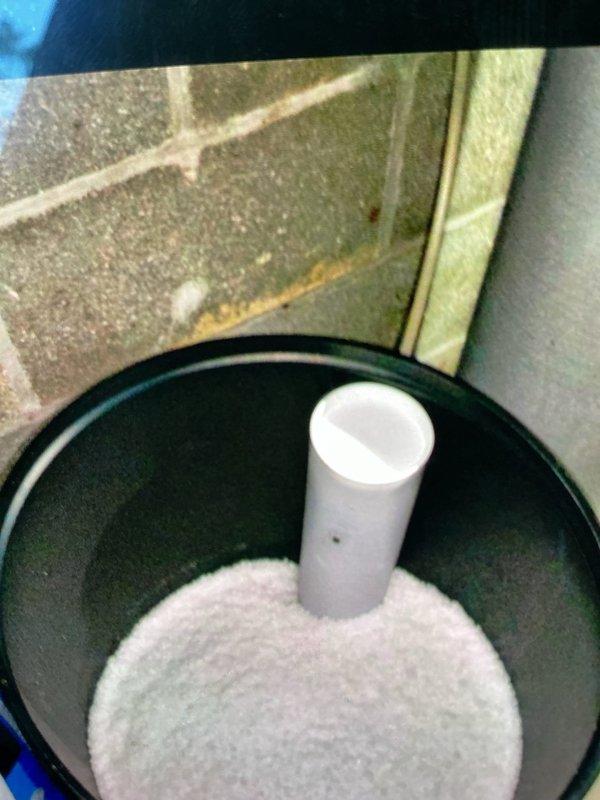 Delivered and loaded six bags of water softener salt to residential water conditioning system. Verified system operation and checked water hardness settings, which displayed 28 grains on the digital control panel. Replenished salt reservoir with granular salt media to ensure continued proper function of the water softening unit.