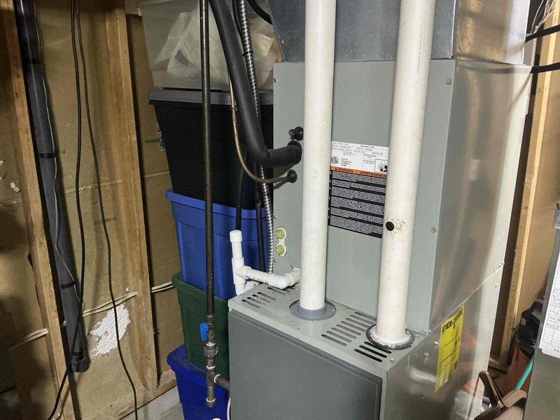 Conducted HVAC system replacement consultation for a 13-year-old air conditioning unit that had previously required repair work exceeding typical maintenance costs. Assessed existing furnace and air handler installation in basement utility area, documenting current system configuration including PVC condensate drainage, ductwork connections, and equipment positioning. Presented replacement options and discussed available manufacturer rebates, energy efficiency benefits of newer systems, and loyalty program credits applicable toward new equipment installation.