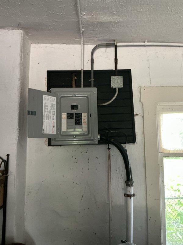 Completed comprehensive assessment of existing electrical panel and service entrance for potential upgrade. Inspected interior main electrical panel with exposed circuit breakers and directory labeling, adjacent sub-panel or auxiliary electrical enclosure, and associated conduit runs including both rigid and flexible metal conduit connections. Evaluated exterior service entrance components including weatherhead, service drop connections, meter base, and PVC conduit routing. Documented current electrical infrastructure condition and provided detailed photographic evidence to support upgrade recommendations and quote preparation.