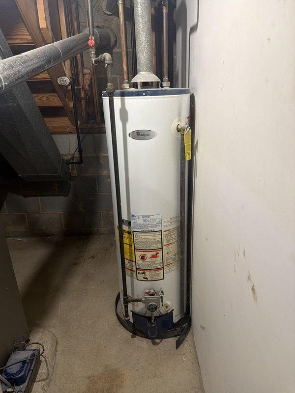 Responded to no hot water complaint and conducted on-site evaluation of existing Whirlpool tanked water heater installation in basement utility area. Inspected unit configuration, plumbing connections, safety strapping, and venting system to assess current condition and provide revised estimate options for replacement or repair. Documented equipment specifications and installation parameters with photographs for estimate preparation.