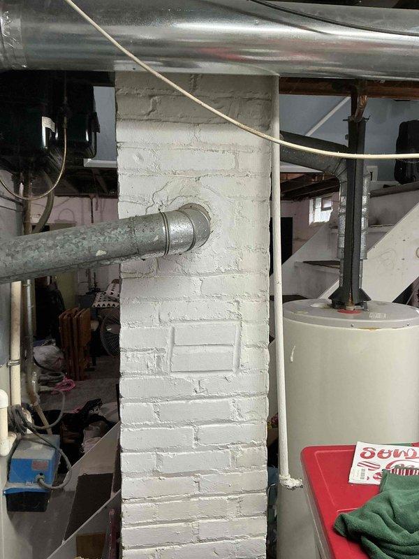 Conducted free replacement estimate for existing furnace and air conditioning system in residential property. Evaluated aging HVAC equipment located in unfinished basement utility area, including furnace unit with visible EnergyGuide labeling and associated ductwork system. Assessed condition of galvanized steel ductwork running from furnace unit along exposed ceiling joists. Documented existing system configuration through photographic documentation showing furnace installation against concrete block wall, metal supply ductwork, and basement mechanical room layout. Provided replacement recommendations and equipment options for both heating and cooling systems based on current installation conditions and space requirements.