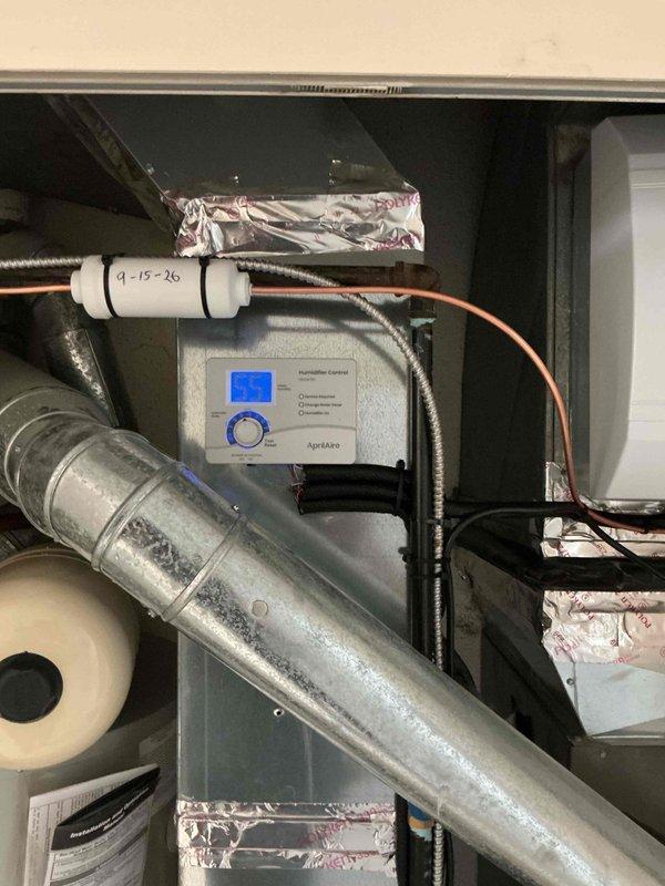 Completed full humidifier system replacement including installation of new AprilAire 700 whole-house humidifier unit with digital control panel. Removed existing humidifier assembly and replaced all associated components including mounting hardware, water supply lines, drainage system, and electrical connections. Integrated new humidifier into existing HVAC ductwork, secured all duct connections with foil tape, verified proper electrical wiring and conduit routing, and programmed digital control unit. System tested and confirmed operational with proper humidification output to supply plenum.