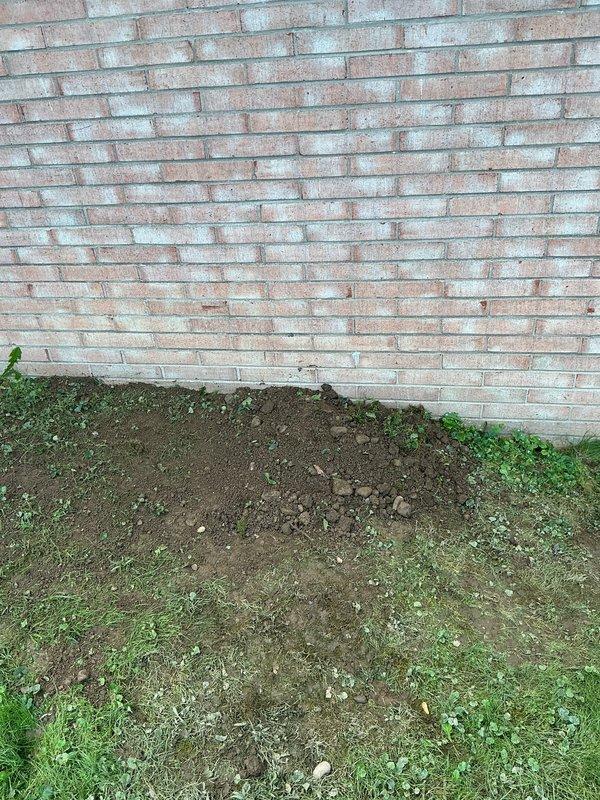 Excavated along exterior foundation wall to access deteriorated underground drainage system. Removed and replaced failed wye fitting and copper drain lines serving two bathroom groups and kitchen. Installed new drainage piping to restore proper wastewater flow from all affected fixtures. Backfilling arranged with separate contractor, with landscaping and grass restoration excluded from scope of work.