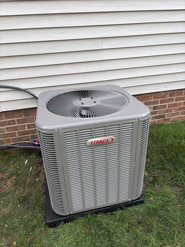 Completed full HVAC system installation consisting of an 80% efficiency furnace and air conditioning system. Installed new Lennox condenser unit on exterior pad with proper clearances from building structure, positioned on black plastic base pad with adequate airflow access on all sides. Routed refrigerant lines and electrical conduit from outdoor unit to interior furnace location, securing black electrical conduit along brick foundation using appropriate mounting clips and following building contours. Connected all electrical components including new meter connections, junction boxes, and service disconnect. Installed gray PVC and flexible metallic conduit for proper line protection and code compliance. Verified all electrical connections are secure and properly grounded. System tested and confirmed operational with proper airflow, refrigerant charge, and temperature differentials meeting manufacturer specifications.