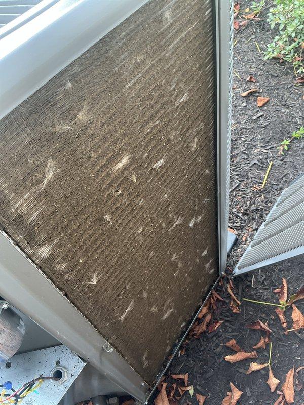 Responded to service call for Lennox AC unit making noise during startup. Upon inspection, found condenser coils heavily soiled with accumulated dirt, debris, and organic material restricting airflow. Cleared vegetation from around unit perimeter and cleaned condenser coils to restore proper operation and eliminate startup noise.