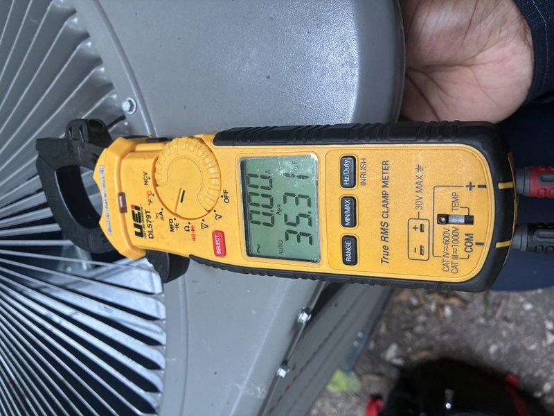 Performed MVP air conditioning maintenance on outdoor condensing unit. Inspected heat exchanger coil which showed significant accumulation of dirt, dust, leaves, and organic debris between fins, indicating extended service period without cleaning. Took electrical measurements using clamp meter, recording amperage readings of 27.7A and 25A to verify proper compressor and fan motor operation. Unit exhibited typical outdoor weathering patterns consistent with normal exposure conditions.