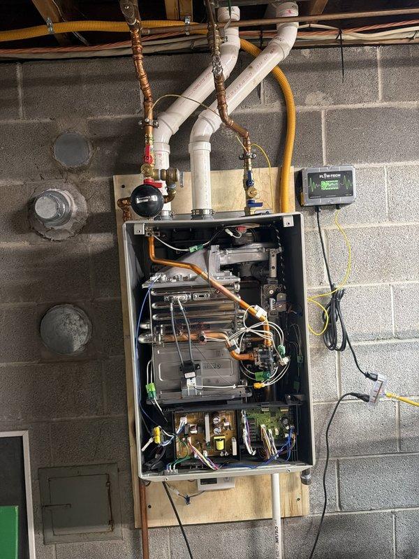 Inspected wall-mounted Noritz tankless water heater unit with customer present. Documented internal components and current installation configuration including heat exchangers, control boards, gas line connections, and PVC venting system. Advised customer to contact Noritz technical support directly regarding case number 373295 for CRM/primary and secondary heat exchanger parts that will be shipped directly to the property for future installation.
