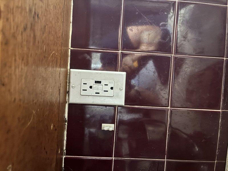 Replaced defective GFCI outlet that was producing clicking noises in tiled wall area. Customer-supplied replacement outlet was installed and tested for proper ground fault protection. Verified circuit breaker connection at main electrical panel and confirmed all safety functions operational upon completion.