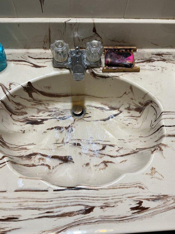 Responded to service call for slow draining kitchen sink and three bathroom drains experiencing backup issues. Upon arrival, performed diagnostic assessment of all affected fixtures. Kitchen sink showed signs of drainage obstruction with double-basin stainless steel configuration requiring attention. Bathroom sink displayed evidence of severe backup conditions with extensive staining throughout basin and countertop surfaces indicating prolonged drainage problems.

Cleared blockages from main drain lines servicing kitchen and bathroom fixtures using appropriate drain cleaning equipment. Restored proper water flow and drainage function to all affected sinks. Verified successful clearance by testing each fixture for adequate drainage speed and confirming no remaining backup conditions. All drains now operating within normal parameters.