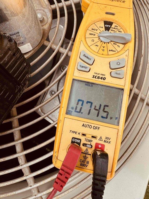 Responded to no cooling complaint on 8-year-old residential air conditioning system. Upon arrival, confirmed unit was running but delivering warm air to living space. Performed diagnostic testing on outdoor condensing unit and identified failed dual run capacitor. Capacitor showed visible signs of age, corrosion, and environmental exposure with heavy dirt and cobweb accumulation on component and surrounding electrical connections. Used Fieldpiece SC640 meter to verify capacitor failure with readings well below manufacturer specifications. Explained findings to customer and discussed repair versus replacement options given system age and overall condition of equipment. Customer expressed interest in system replacement but authorized immediate capacitor replacement to restore cooling. Replaced defective capacitor with properly rated OEM equivalent, verified all electrical connections, and tested system operation. Unit cycled properly with compressor and condenser fan motor running at cor