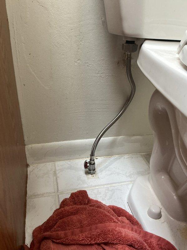 Responded to emergency call for bathroom flooding caused by failed toilet shut-off valve. Upon arrival, found water actively spraying from the valve connection point at the wall supply line. Immediately shut off water supply to the toilet to stop the active leak and prevent further water damage. Removed the defective shut-off valve assembly, which showed signs of internal seal failure. Installed new angle stop valve with fresh supply line connection. Tested the new valve installation for proper operation and verified no leaks at connection points. Restored water supply and confirmed toilet fill valve functioning correctly with no water spray or seepage.