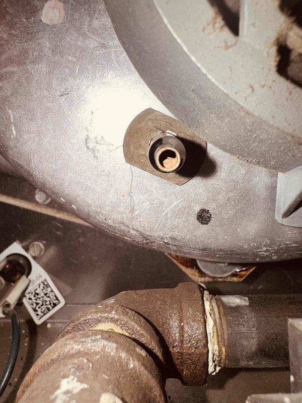 Completed comprehensive tune-up and safety inspection on 15-year-old residential furnace system for shared living facility licensing compliance. Inspected blower assembly, verified proper operation of circular air distribution vent with radial louver design, and examined all mechanical connections and gas piping components. Documented system condition with photographs showing blower housing, heat exchanger access points, and gas line connections with visible age-related surface oxidation on fittings; confirmed all components operating within safe parameters with no immediate safety concerns identified.