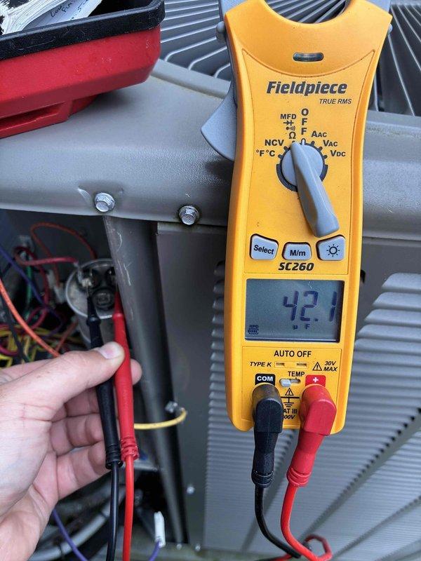 Completed MVP AC maintenance on cooling system. Performed electrical diagnostics using clamp meter, recording amperage reading of 42.1 amps to verify compressor operation within manufacturer specifications. Inspected capacitor and associated electrical connections, noting weathering on component surface but confirming all wire terminations secure at terminal blocks.