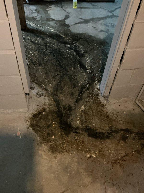 Responded to emergency call for main drain line blockage causing extensive water backup and flooding in basement area. Successfully cleared main drain line obstruction, restoring proper drainage flow and eliminating sewage backup affecting concrete floor surfaces near doorway threshold and utility room space.