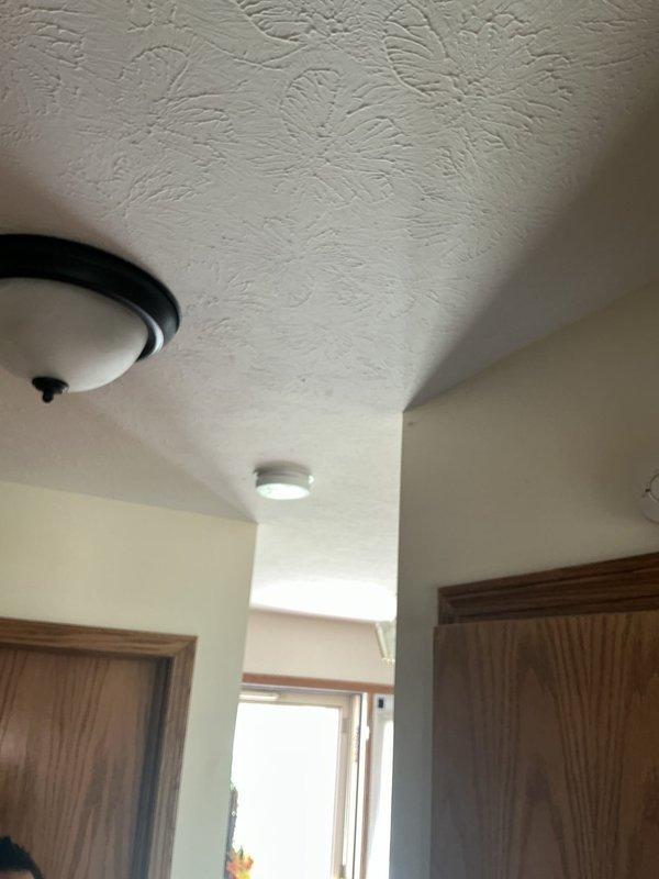 # Electrical Service - Fire Alarm System

Responded to service call regarding fire alarm communication issues. Customer reported that smoke detectors were not interconnected and would not sound simultaneously in the event of a fire activation. Upon arrival, conducted visual inspection of existing ceiling-mounted smoke detector fixtures throughout the residence. Evaluated current fire alarm configuration and identified that existing units were not properly networked for synchronized alarm operation. Documented existing ceiling fixture locations and mounting conditions in hallway and living areas. Assessed electrical infrastructure and determined requirements for installing interconnected smoke detector system to ensure all units activate together when smoke is detected by any single device. Provided technical consultation on code-compliant fire alarm solutions and prepared estimate for complete interconnected smoke detector installation to meet safety requirements.
