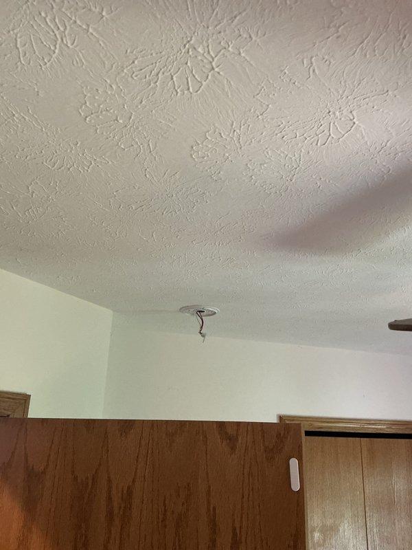 # Electrical Service - Fire Alarm System

Responded to service call regarding fire alarm communication issues. Customer reported that smoke detectors were not interconnected and would not sound simultaneously in the event of a fire activation. Upon arrival, conducted visual inspection of existing ceiling-mounted smoke detector fixtures throughout the residence. Evaluated current fire alarm configuration and identified that existing units were not properly networked for synchronized alarm operation. Documented existing ceiling fixture locations and mounting conditions in hallway and living areas. Assessed electrical infrastructure and determined requirements for installing interconnected smoke detector system to ensure all units activate together when smoke is detected by any single device. Provided technical consultation on code-compliant fire alarm solutions and prepared estimate for complete interconnected smoke detector installation to meet safety requirements.