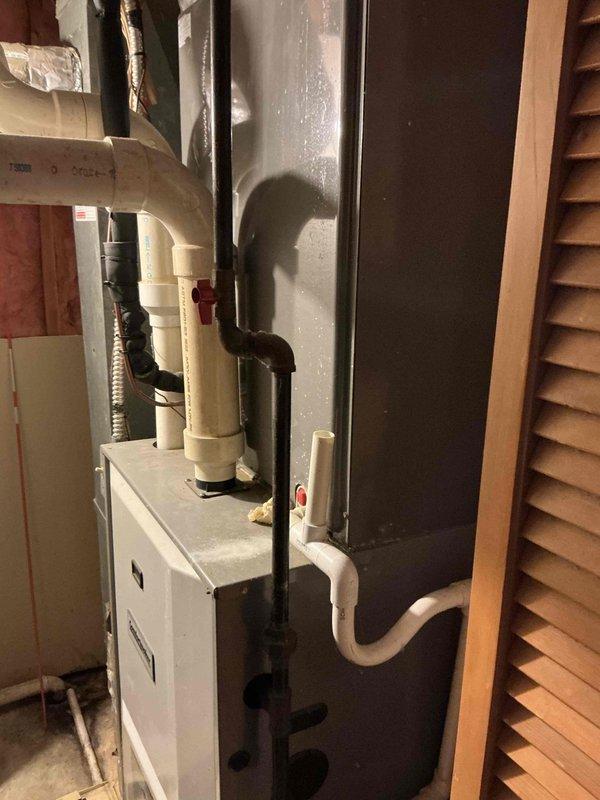 Conducted comprehensive HVAC estimate for air conditioning replacement at residential property. Evaluated existing Comfortmaker furnace system and associated components including humidifier, ductwork, and electrical connections in basement utility area. Documented current installation configuration with detailed photography showing furnace unit, PVC drainage lines, copper refrigerant lines, flexible ductwork, and electrical wiring for replacement planning purposes.