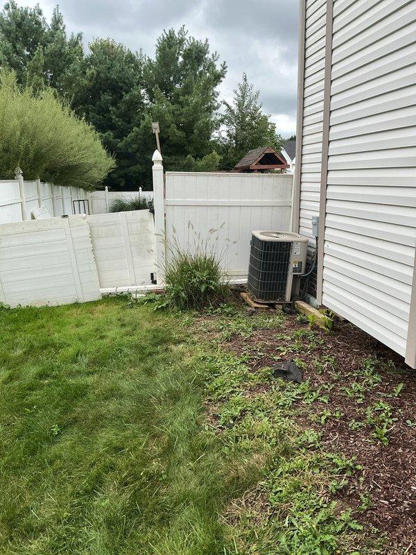 Responded to service call for broken underground downspout drainage pipe located at rear left side of property near fence line. Conducted on-site assessment and documented conditions, including HVAC unit settling issues potentially related to drainage problems. Provided free estimate for repair or replacement of damaged underground drainage system, with photographic documentation of affected areas showing debris accumulation and vegetation growth around exterior mechanical equipment.