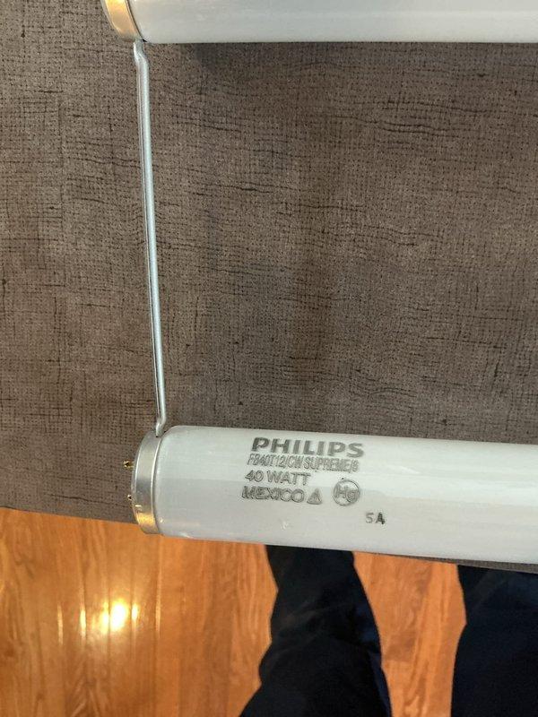 Replaced fluorescent light tubes in kitchen ceiling fixtures. Customer had replacement bulbs available but was unable to access the ceiling-mounted fixtures due to height limitations. Removed existing Philips F40T12/CW 40-watt fluorescent tubes from recessed ceiling fixtures and installed new tubes provided by customer. Verified proper operation of all fixtures upon completion.