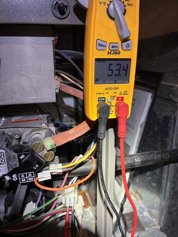 Completed scheduled MVP heating maintenance visit. Performed diagnostic testing on HVAC control system using digital multimeter, recording voltage readings at 5.94V on system wiring and control board connections. Inspected circuit board components including integrated circuits, relay assemblies, and air sensor terminal connections to verify proper operation and system functionality.
