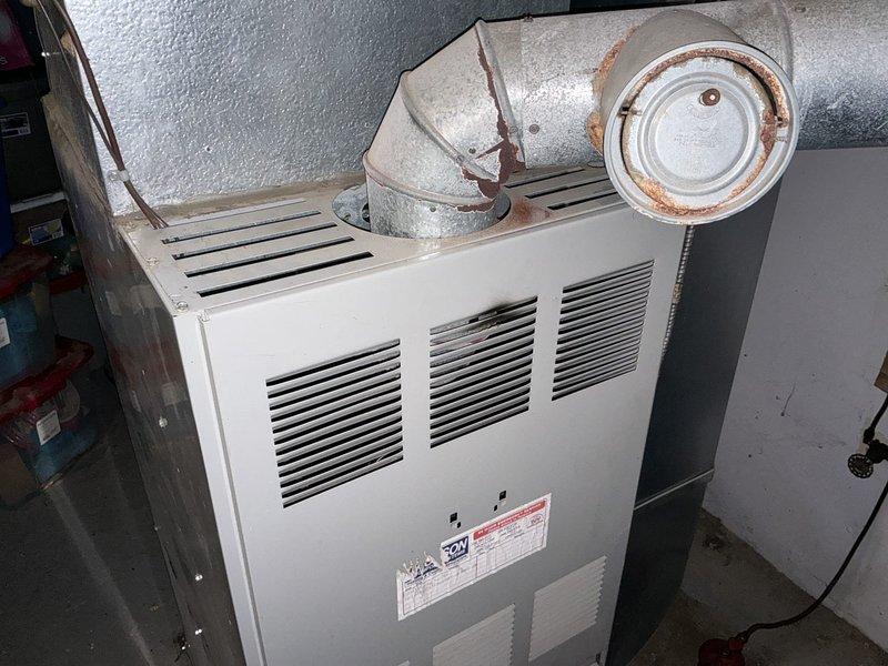 Completed estimate for replacement of 20-year-old oil furnace system with potential conversion to propane fuel source. Evaluated existing furnace unit showing significant age-related deterioration, including rust formation on ductwork connections and galvanized metal components. Provided comprehensive quote for complete system replacement to address aging equipment and fuel conversion requirements.