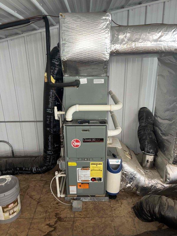 Completed recurring MVP heating maintenance visit on three furnace systems located in basement, outbuilding, and upstairs areas. Performed comprehensive inspections and maintenance procedures on all units, including a Rheem Classic 80 furnace system with associated ductwork and plenum assembly. Inspected and verified proper operation of Honeywell whole-house humidifier unit mounted on HVAC ductwork, confirming water supply line connections, electrical wiring, and solenoid valve functionality. Checked all PVC venting, reflective insulated ductwork, and flexible duct connections for proper sealing and installation. Verified furnace safety controls, burner operation, and airflow throughout all three heating systems. All units found to be operating within manufacturer specifications and ready for continued service.