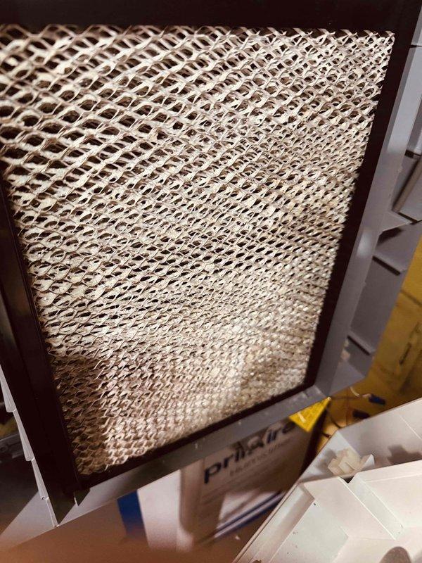 Completed MVP heating maintenance inspection and documentation. Examined evaporative cooler media pad showing moderate mineral deposits and dust accumulation in lower sections, with honeycomb structure intact and functional. Inspected control board terminal connections and verified proper wire terminations on all colored conductors including power and control circuits.