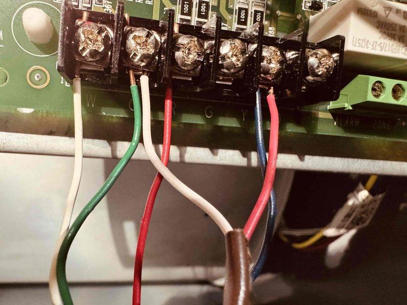 Completed MVP heating maintenance inspection and documentation. Examined evaporative cooler media pad showing moderate mineral deposits and dust accumulation in lower sections, with honeycomb structure intact and functional. Inspected control board terminal connections and verified proper wire terminations on all colored conductors including power and control circuits.