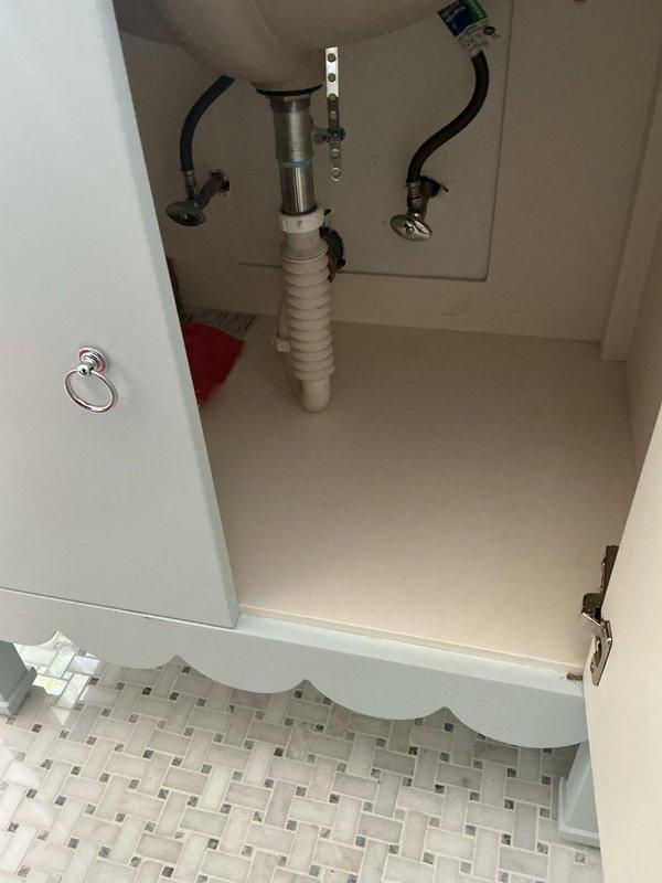 Responded to callback for ongoing sink issues following previous repair visit. Conducted thorough inspection of bathroom sink plumbing system and drain assembly. Examined P-trap configuration, supply line connections, and faucet mounting to identify source of continued problems. Photographed existing plumbing setup including corrugated P-trap, flexible supply lines, and drain components for documentation. Assessed overall condition of vanity cabinet plumbing and discussed repair options with customer to resolve persistent sink malfunction.