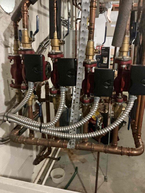 Completed recurring maintenance visit for mini-split and hydronic heating system. Inspected four-zone circulator pump manifold assembly with brass fittings and copper distribution piping, verified proper operation of all pump units and associated controls, and documented system condition through photographic records. All equipment found operating within normal parameters with no immediate service needs identified.