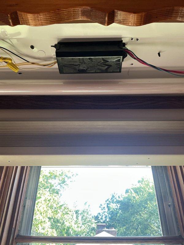 Responded to flickering kitchen light fixture above sink area. Upon inspection, identified existing motorized window shade system with electrical connections requiring assessment for proper fixture replacement sizing and compatibility. Documented existing wiring configuration and fixture dimensions to determine appropriate replacement unit specifications for subsequent installation visit.