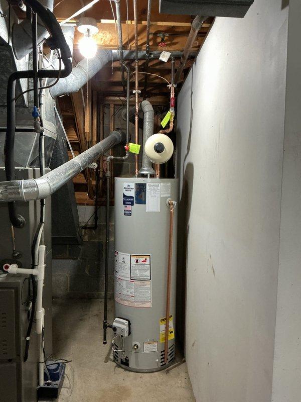 Installed a new 40-gallon tall residential water heater with a 10-year warranty in basement utility room. Installation included a ball valve shut-off, white expansion tank mounted on copper supply lines, and proper electrical bonding for code compliance. Removed and hauled away the existing water heater as requested, staged all necessary components from shop inventory, and completed all copper pipe connections with soldered joints. System was pressure tested, all safety valves verified operational, and unit commissioned successfully with no leaks detected.