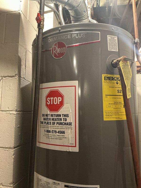 Responded to service call for tanked water heater issue at residential property. Upon arrival, inspected Rheem Performance Plus model water heater unit installed in basement utility room. Evaluated water heater operation, connections, and safety components including pressure relief valve, copper supply lines, and red-handled shut-off valve. Verified proper venting and ductwork configuration. Assessed unit specifications, energy efficiency ratings, and manufacturer labels for compliance. Documented equipment condition and installation with photographs for service records. All safety warnings and operational parameters were reviewed to ensure system functionality.