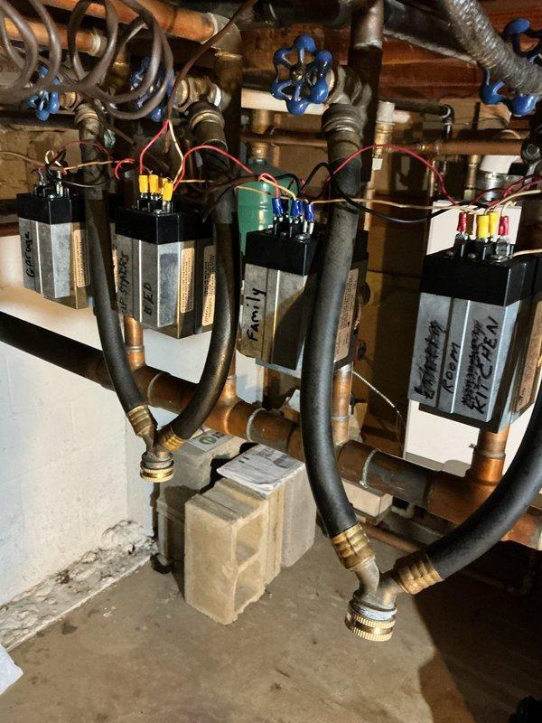 Responded to service call for wall-mounted gas boiler system with seven heating zones experiencing operational issues. Replaced three defective zone valves on the multi-zone manifold assembly; two additional valves continue to exhibit leaking and require further attention or replacement. Troubleshot igniter malfunction on the gas boiler unit. System shows signs of age with visible corrosion on copper piping components throughout the installation.