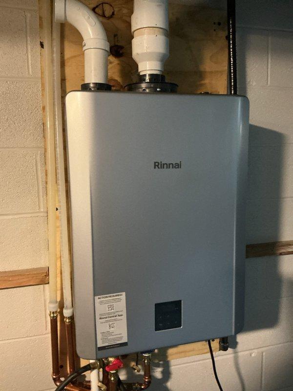 Completed hot water tank flush and fill service on the residential water heating system. Upon inspection, the unit was a Rinnai tankless water heater, not a traditional tanked system, so maintenance procedures were adjusted accordingly. Performed standard maintenance including system inspection, verified proper venting through white PVC intake and exhaust pipes, checked copper water line connections and shut-off valves for proper operation, and confirmed unit functionality through the digital control panel.
