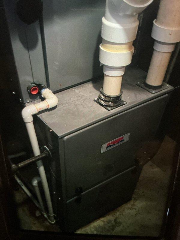 Completed scheduled heating maintenance visit on 6-year-old HVAC system. Performed comprehensive inspection of furnace unit located in basement utility area. Examined all PVC venting connections, noting age-appropriate discoloration on condensate and exhaust piping. Verified proper drainage through condensate system with red float indicator. Inspected control board and electrical components within main panel, confirming all relay switches, capacitors, and integrated circuits functioning properly. Checked transformer connections and verified secure wire management throughout system. Documented equipment condition with photographs for maintenance records. System operating within normal parameters upon completion of inspection.