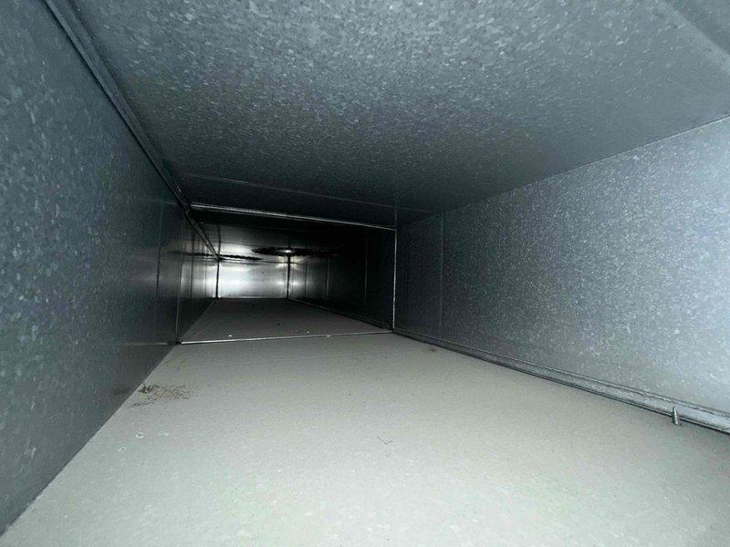 Completed comprehensive duct cleaning service for residential HVAC system. Thoroughly cleaned all accessible ductwork including main trunk lines and branch runs, removing accumulated dust, debris, and particulate matter using professional rotary brush system and high-powered negative air vacuum equipment. Interior duct surfaces, including insulated duct board walls and metal flooring sections, were agitated and extracted to restore proper airflow and indoor air quality. All work performed while insured, and photographic documentation captured showing clean duct interiors with gray fibrous insulation liner and smooth beige flooring post-cleaning.